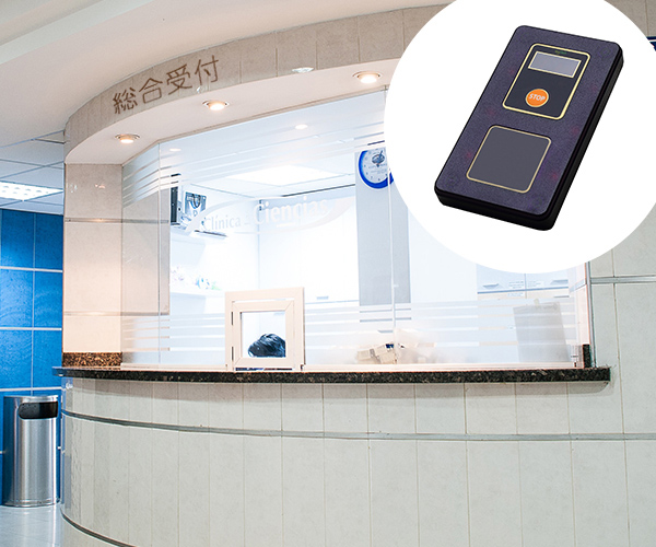 病院・薬局・クリニックの受付で受信機を渡す